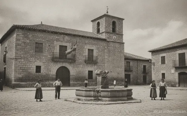 Historic Spanish village square in Castilla-La Mancha, stone architecture from the 1930s era, black and white photography ...