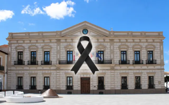 Fachada del Ayuntamiento de Alcázar de San Juan con la bandera a media asta en señal de luto oficial